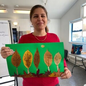 Smiling woman holding an art project with leaves